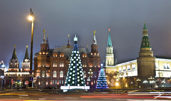 Moscow, Russia - December 15, 2011: Christmas trees on Manezhnaya square, Kremlin, Historical museum and Iverskiye gates-chapel around.