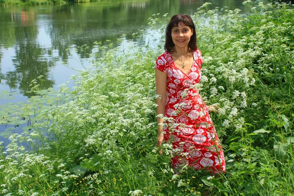 Chica cerca del lago en flores blancas —  Fotos de Stock
