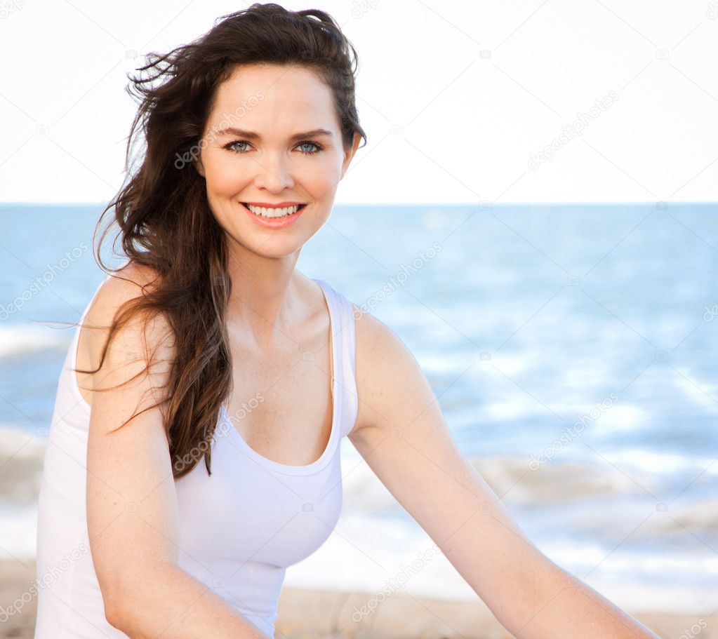 Beautiful healthy woman sitting on beach