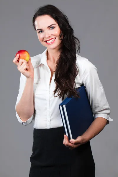 Kadın holding kitap ve elma — Stok fotoğraf