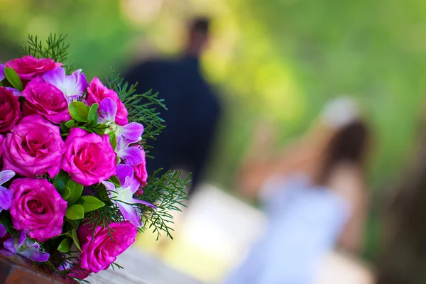 Newly wed couple walking away from a beautiful bridal bouquet — Stock Photo, Image