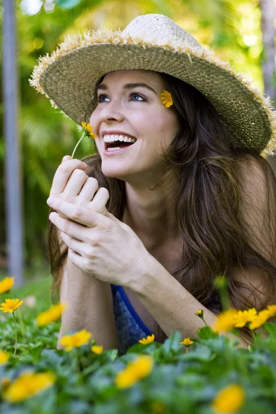 Mulher atraente cheirando flor — Fotografia de Stock