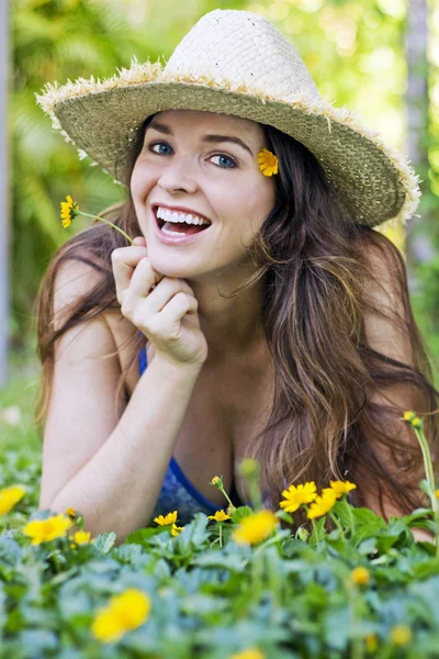 Attractive woman in hat and flowers — Stock Photo, Image