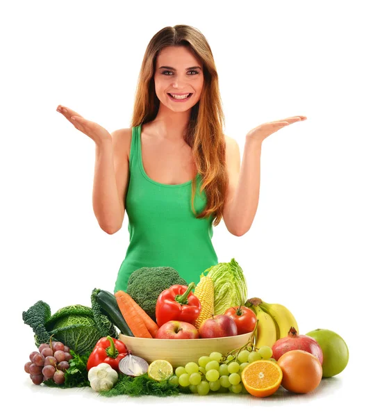 Молодая улыбающаяся женщина с разнообразием свежих овощей и фруктов — стоковое фото