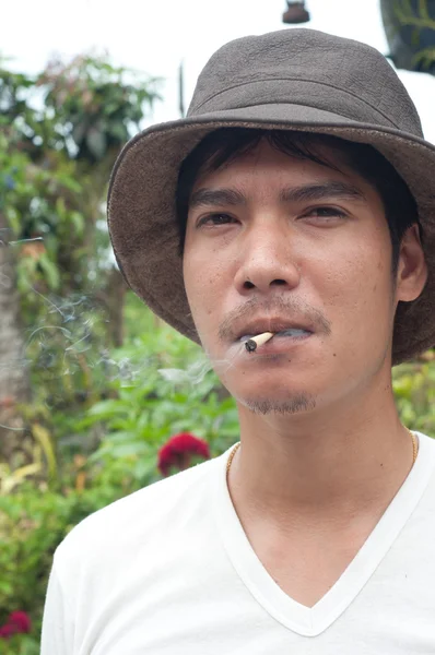 Asian man smoke thai traditional cigarette — Stock Photo, Image