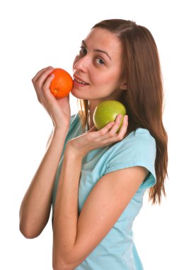 elma ve portakal beyaz üzerinde tutan genç kadın