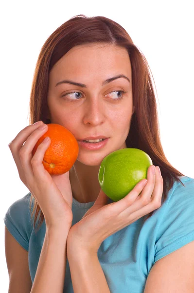 Young woman holding apple and orange over white — Stock Photo, Image