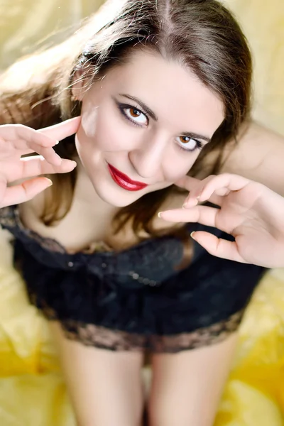 stock image Beautiful girl sitting on a yellow silk