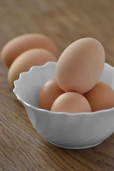 Kuřecí vejce v bílé misce se sýrem na dřevěný stůl — Stock fotografie