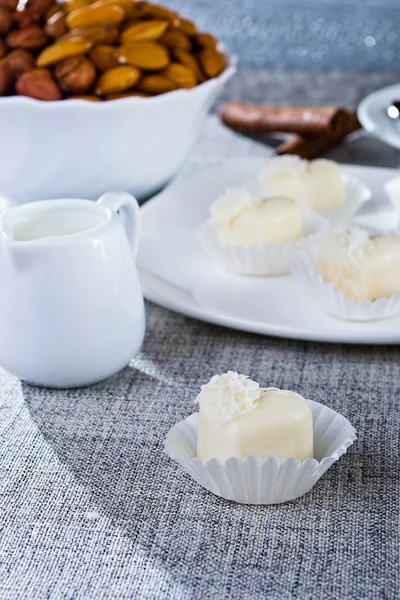 Pralinen in herzförmiger weißer Schokolade auf der Tischdecke — Stockfoto