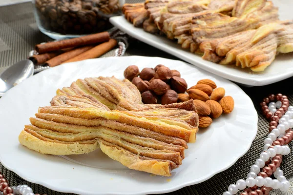 Homemade pastries with cinnamon bows on a white plate — Stock Photo, Image