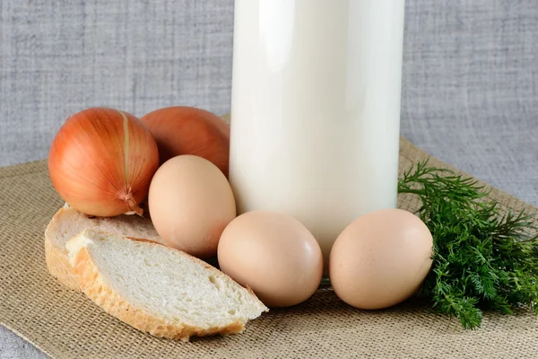 Chicken eggs with slices of bread on the table with milk — Stock Photo, Image