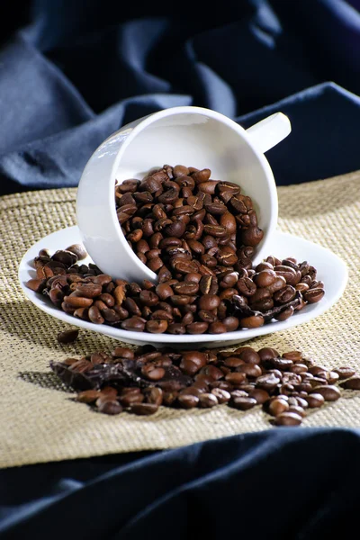 La tasse inversée avec des grains de café — Photo