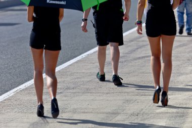 Legs of two Pitbabes and a mechanic on the CEV Championship clipart