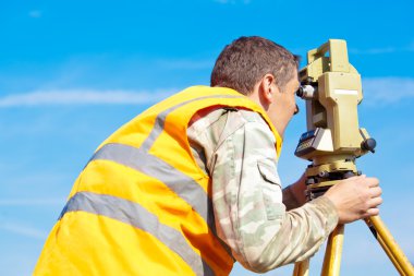 Surveyor engineer making measuring with theodolite clipart