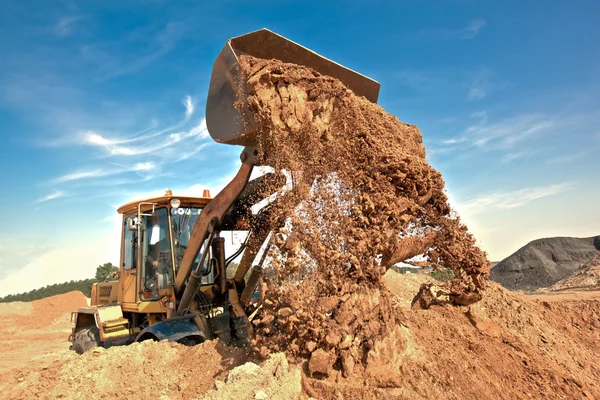 Wiel loader lossen bodem op de bouwplaats — Stockfoto