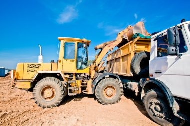 Wheel loader machine loading dumper truck clipart