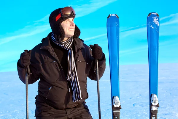 Uśmiechnięty facet narciarz na tle błękitnego nieba — Zdjęcie stockowe