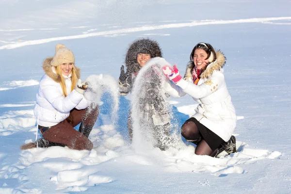 Красивые девушки играют со снегом — стоковое фото