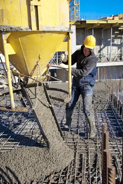 Obrero constructor durante trabajos de vertido de hormigón en obras de construcción Imágenes de stock libres de derechos