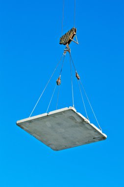 Elevating crane lifting a concrete plate clipart