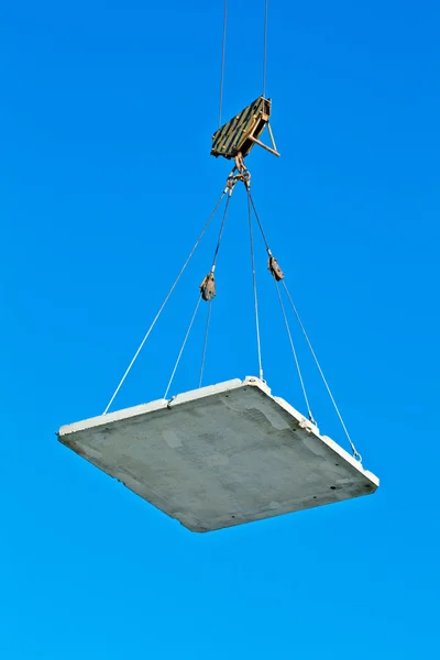 Elevating crane lifting a concrete plate — Stock Photo, Image
