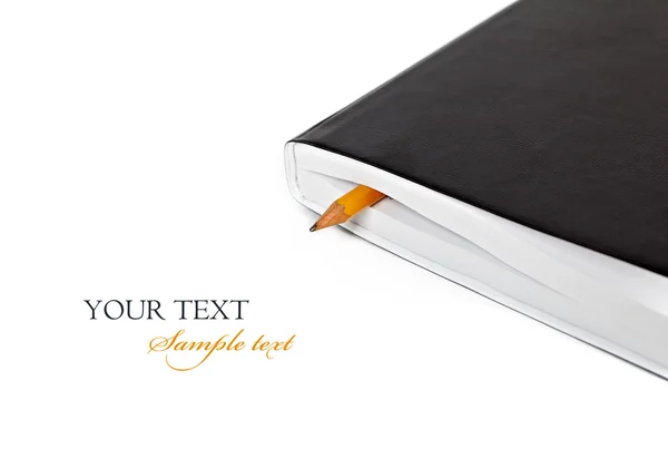 Lápis em um diário sobre um fundo branco — Fotografia de Stock