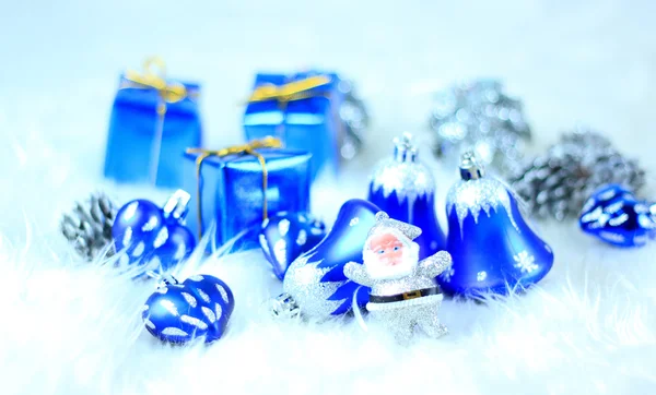 Цветные голубые рождественские украшения на белом снегу — стоковое фото