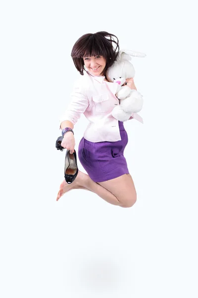 Young beautiful woman jumping in joy with plush rabbit and black shoes — Stock Photo, Image