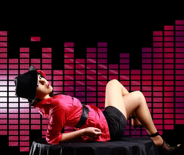 Sexy dáma, ležící na stole, na disco pozadí — Stock fotografie