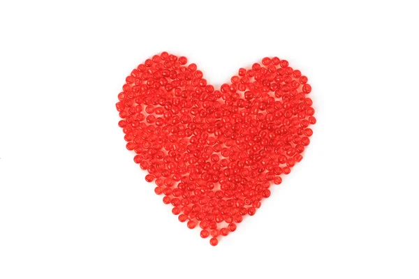 Jantung yang terbuat dari manik-manik merah, terisolasi di latar belakang merah . — Stok Foto