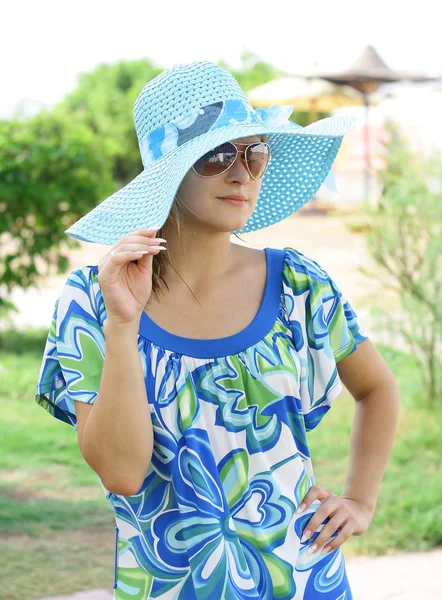 Foto de uma bela jovem mulher em um chapéu na praia — Fotografia de Stock
