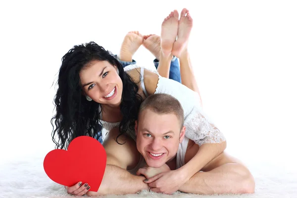Adult couple with red heart lie on the floor — Stock Photo, Image