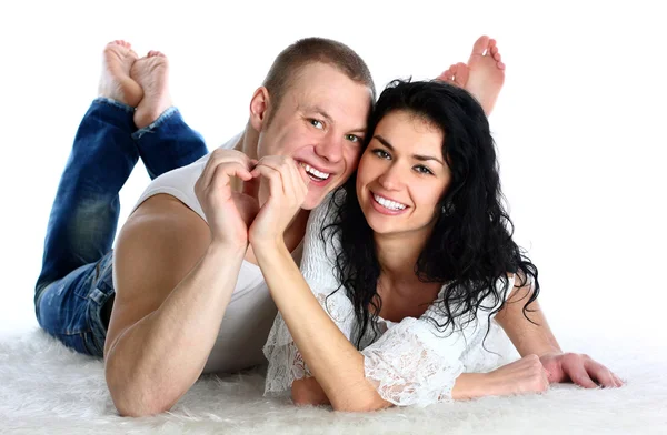Adult couple lie on the floor nd making heart by hands, — Stock Photo, Image