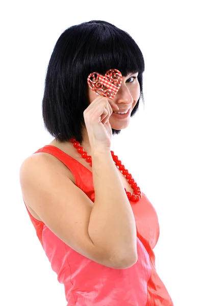 Schattige jonge vrouw houdt een hartsymbool aan haar gezicht — Stockfoto