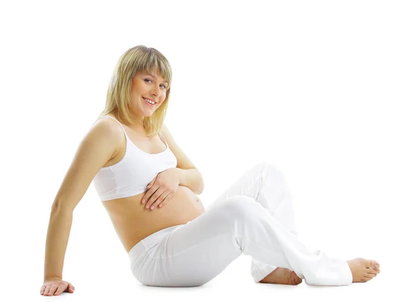 Schöne schwangere Frau, die ihren schönen Bauch berührt - isoliert Stockbild