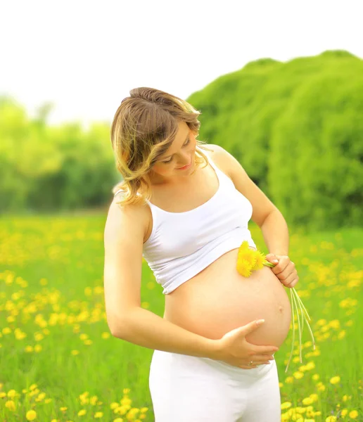 Красивая беременная женщина на лугу — стоковое фото