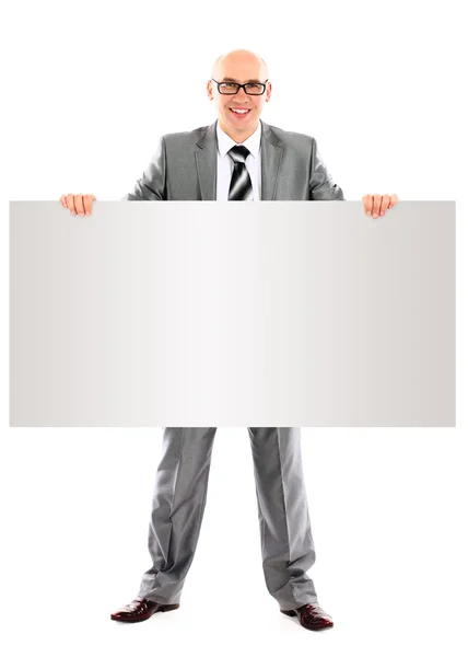 Glücklich lächelnder junger Geschäftsmann zeigt leeres Schild — Stockfoto