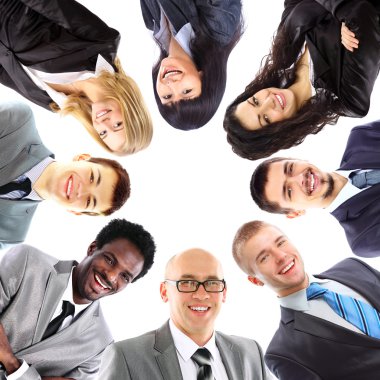 Group of business standing in huddle, smiling, low angle view clipart