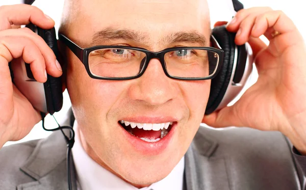 音楽を聴くカメラ、ヘッドフォンを着ているビジネスマンの笑みを浮かべてください。 — ストック写真