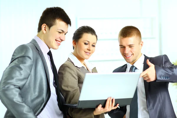 Giovane donna d'affari con i suoi collegi utilizzando laptop — Foto Stock