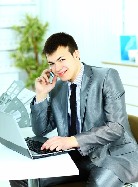 Homem de negócios inteligente usando laptop no escritório moderno — Fotografia de Stock