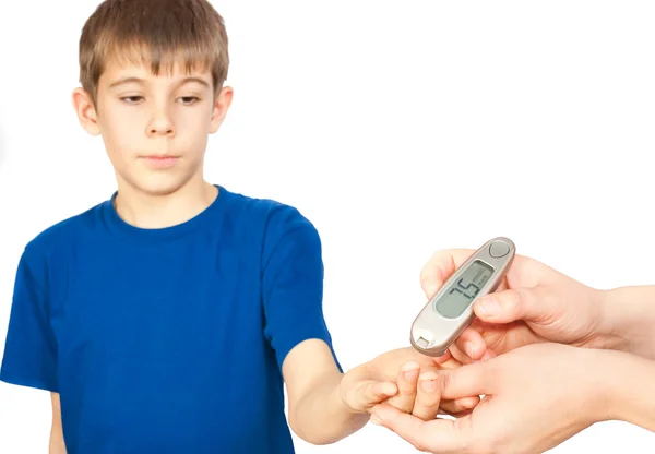 Pojken gör ett test för diabetes Stockbild