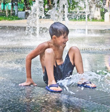 The boy is bathed in the fountain clipart