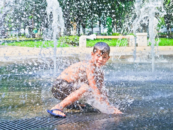 Pojken är badat i fontänen — Stockfoto