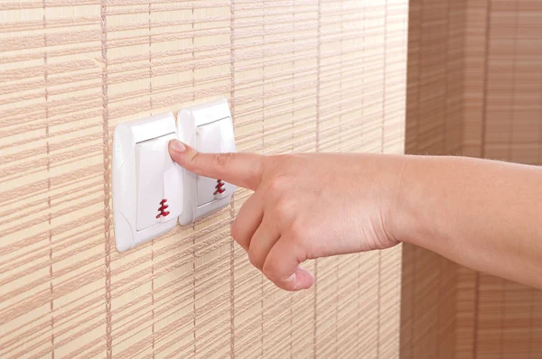 Hand pressed to switch on the wall — Stock Photo, Image