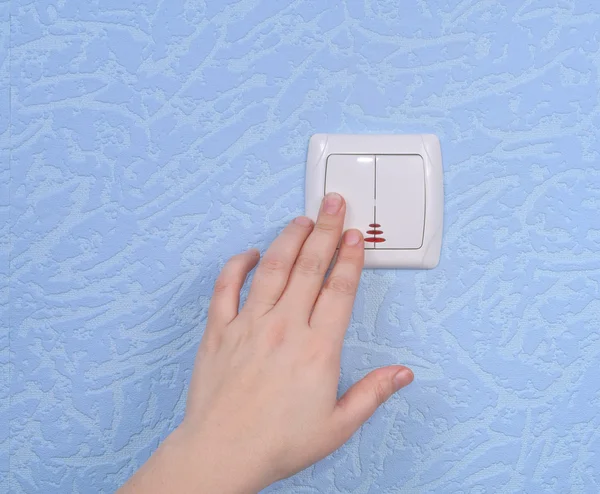 Hand pressed to switch on the wall — Stock Photo, Image