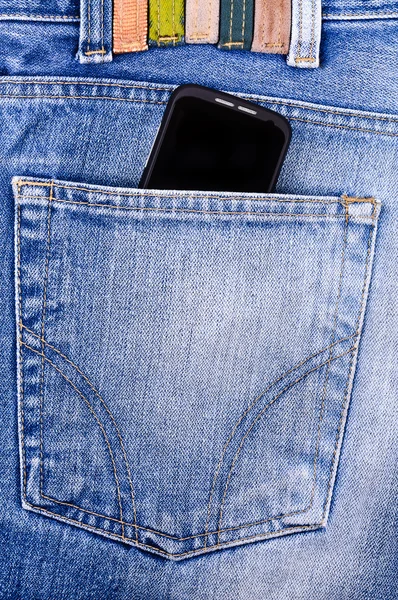 Teléfono móvil en sus pantalones vaqueros de bolsillo — Foto de Stock