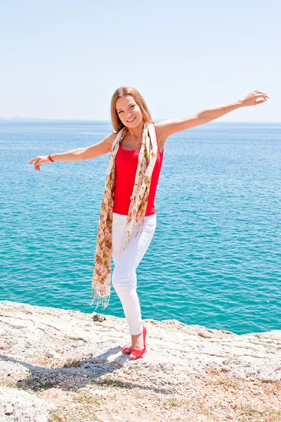 Dívka na skalách proti moři — Stock fotografie