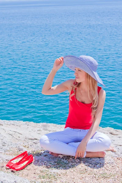 La chica en las rocas contra el mar — Foto de Stock